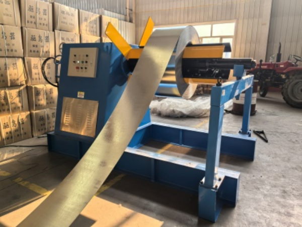 Close-up of the Decoiler section of a Fully Automatic Cable Tray Production Line, featuring a blue frame and a large metal coil being unwound to feed the production process.