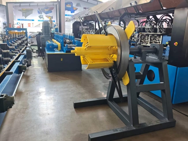 A yellow decoiler feeding a metal strip into a blue Split set roll forming machine in an exhibition hall. The machine is used for manufacturing Rock Bolts.