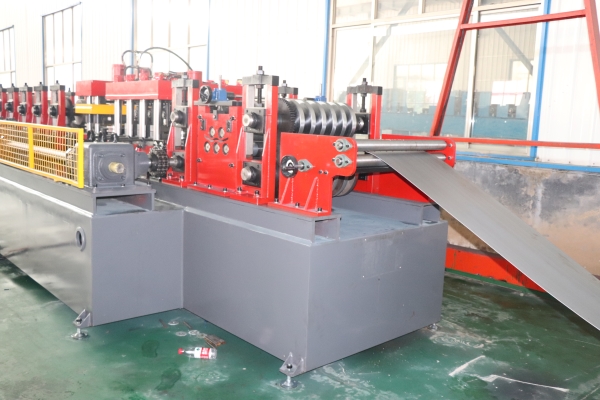 A close-up view of the feeding leveling roller group on a CZ purlin making machine, showing multiple rollers guiding a metal strip.