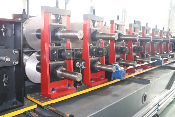 Close-up detail of the roll forming stations on a CZ purlin making machine, showing a series of rollers mounted on red frames along a grey base.
