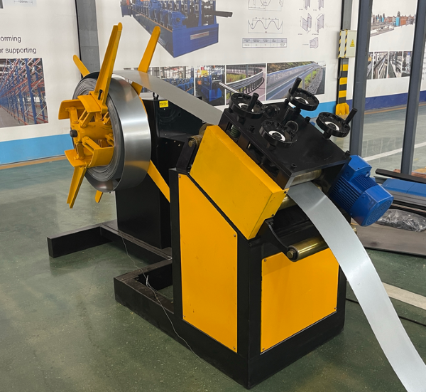 A yellow and black decoiler machine, part of an upright pillar production line, feeding a metal strip into the production process.