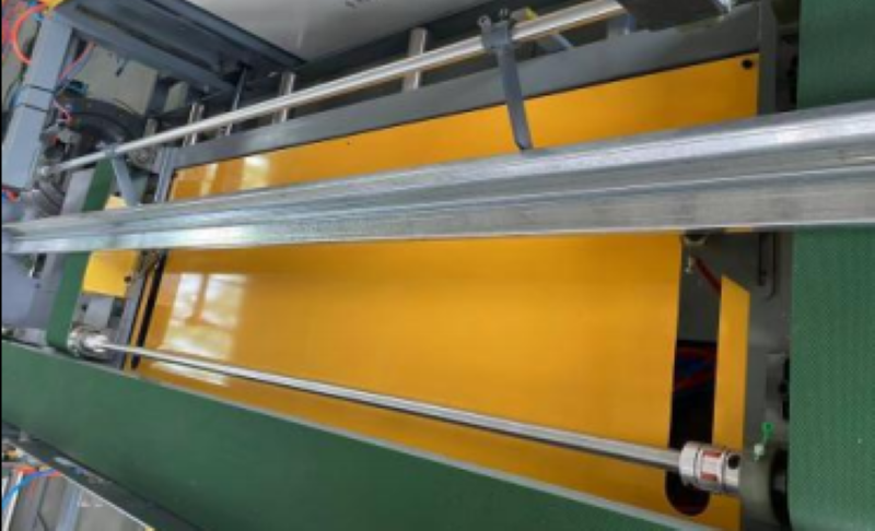 Alignment area where metal profiles are stabilized by side guides and clamping mechanisms during transport.