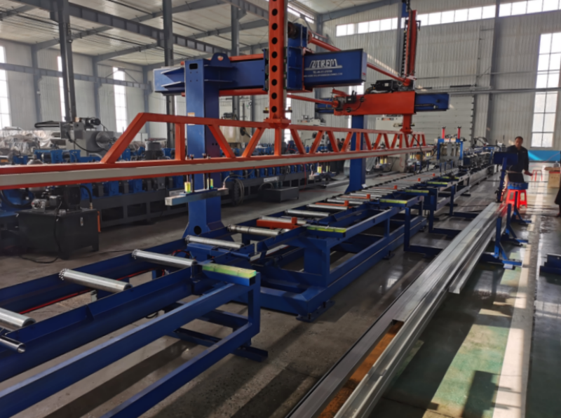 Automatic stacker of a CZ purlin making machine, showing overhead gantry and roller conveyor system for collecting finished profiles.