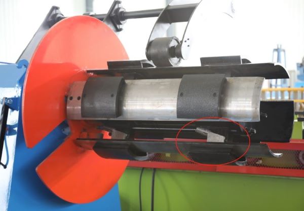 A close-up view of the main shaft on a Hydraulic De-Coiler, highlighting the use of removable gaskets to adjust the inner diameter range between 470-610mm without replacing the shaft.