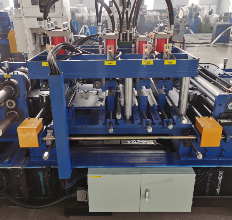 Punching system of a CZ purlin making machine, showing hydraulic cylinders and punch stations mounted on a blue frame with safety guards.