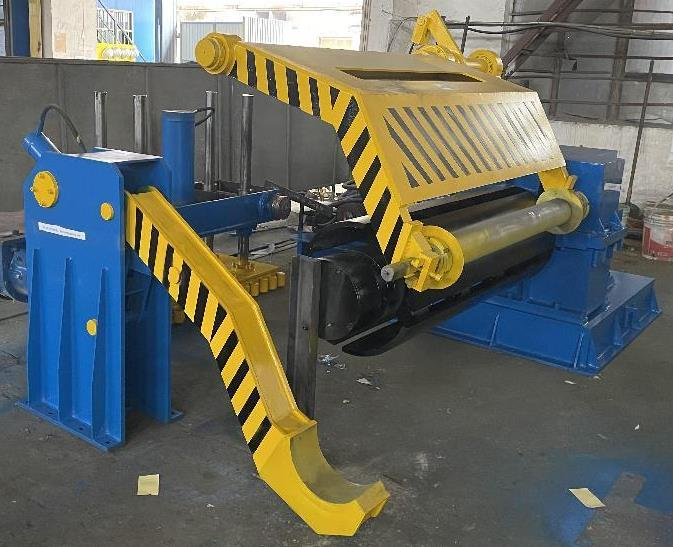 Blue and yellow recoiler unit, part of a hydraulic slitting line, designed to wind finished steel strips with adjustable tension and speed.